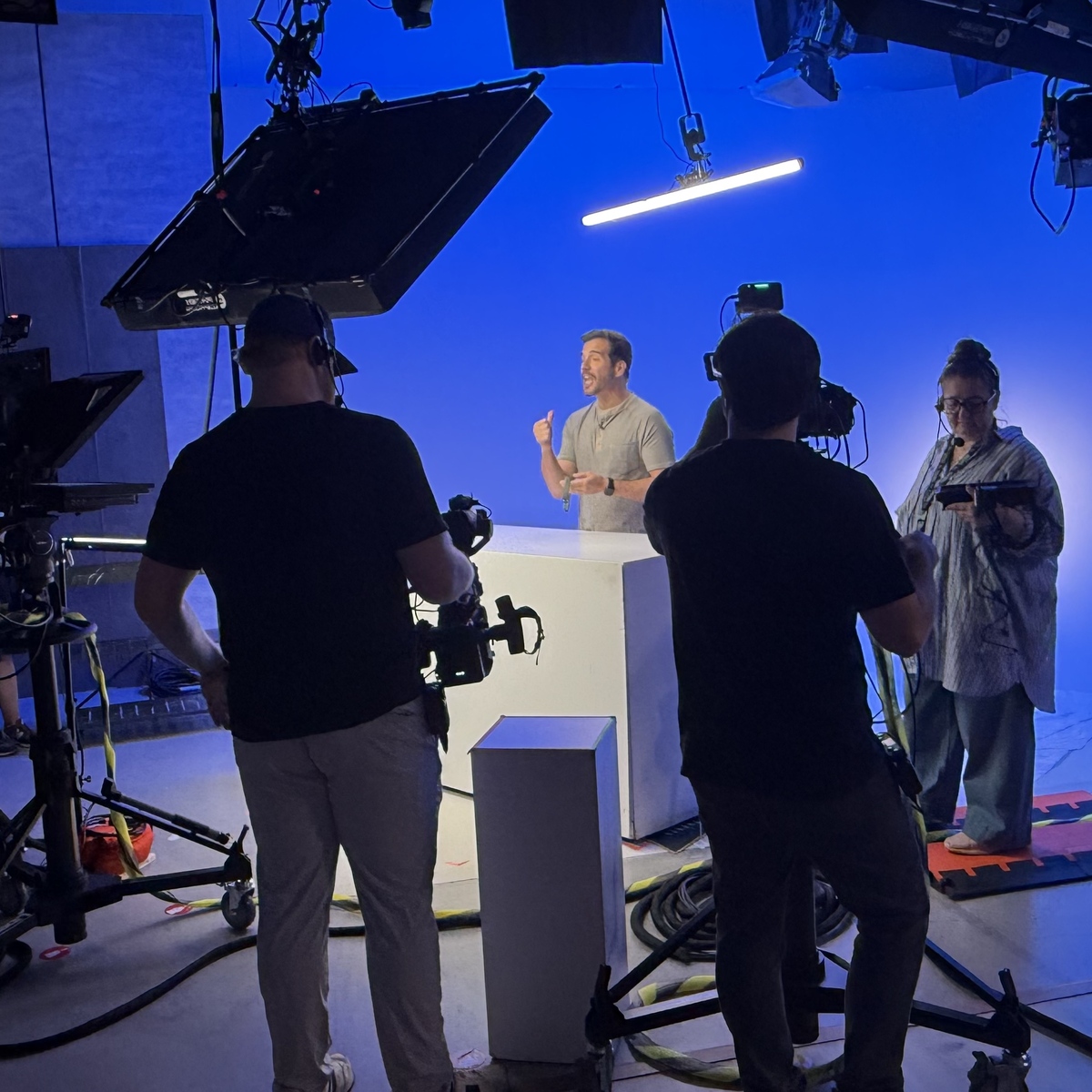 JD Roberto directing on a blue-lit studio set
